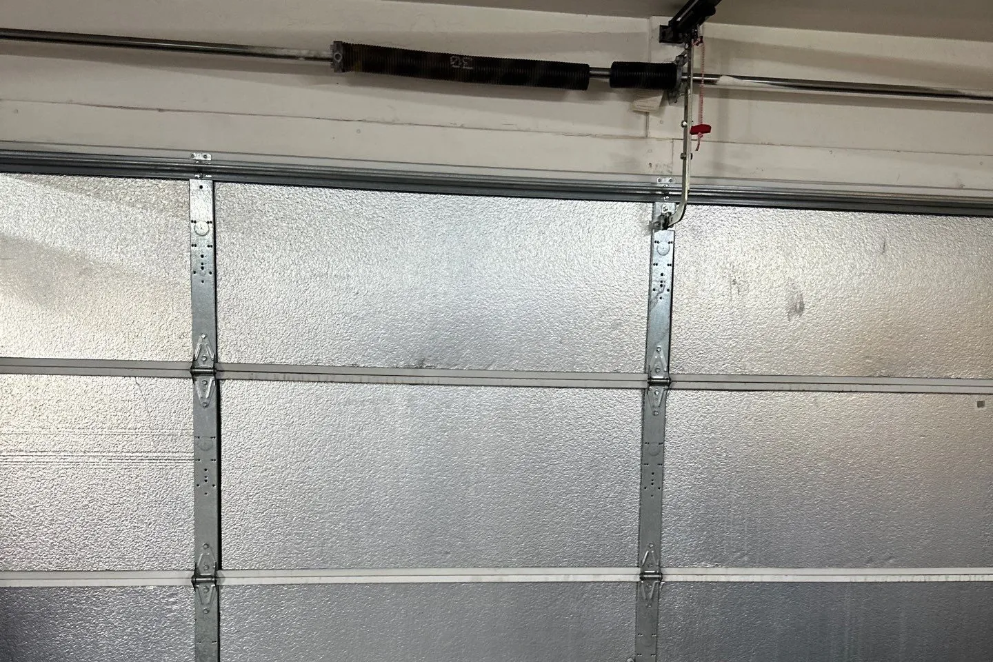 Inside of a garage door with foil insulation panels between the sections