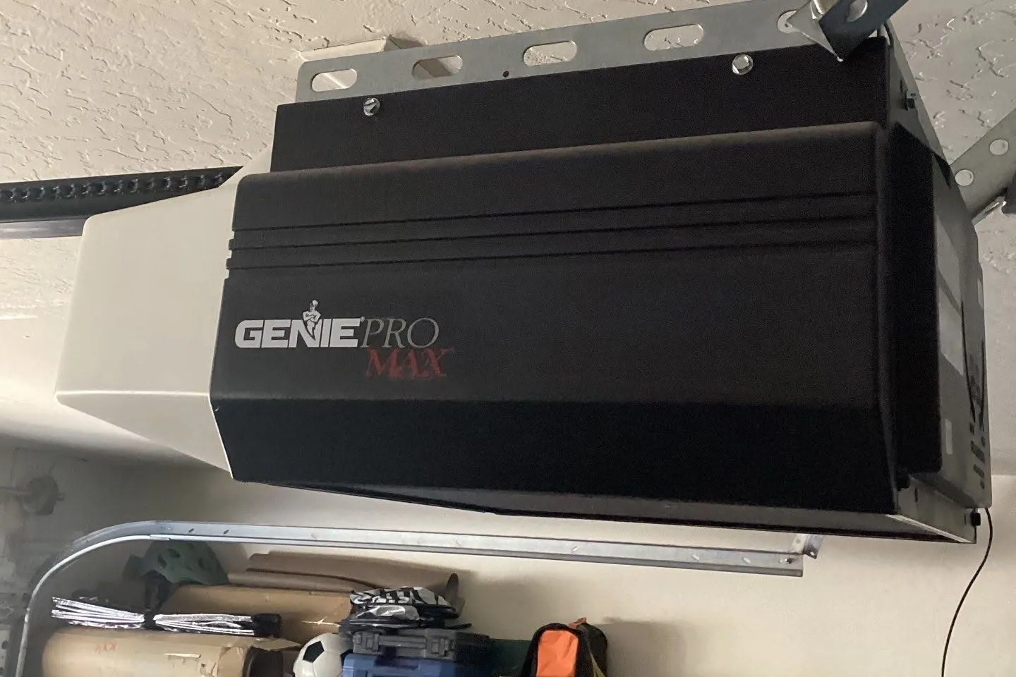 Genie Pro Max garage door opener mounted to a textured garage ceiling
