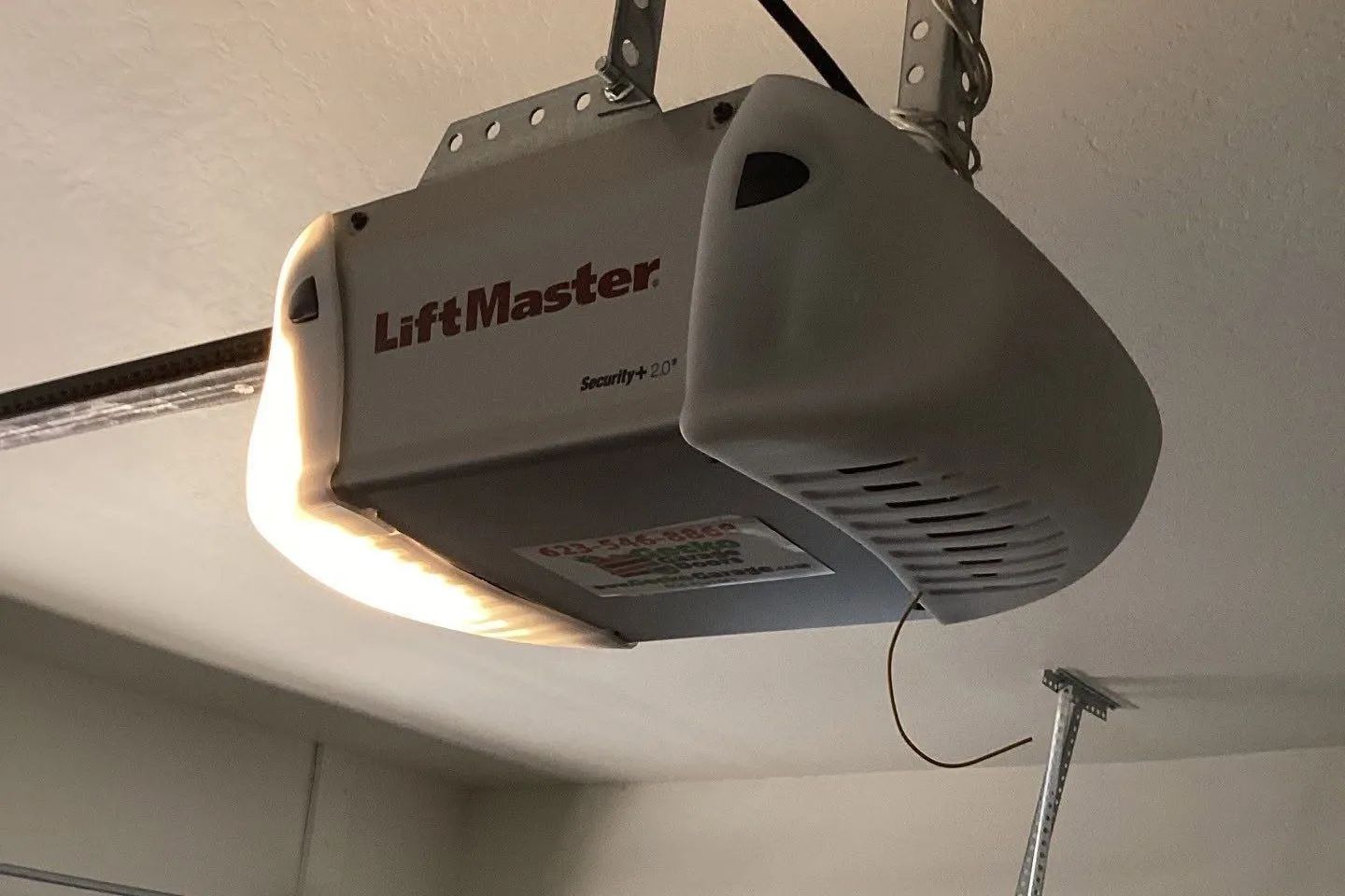 LiftMaster opener and rail above a garage door track and window section