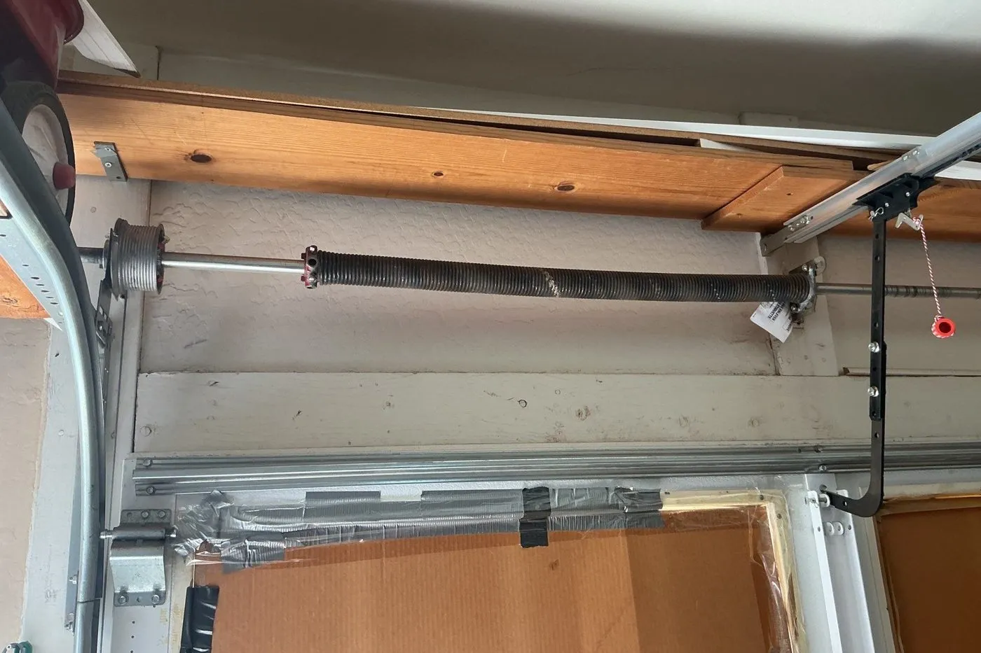 Torsion spring on the shaft above a garage door with the opener arm to the right